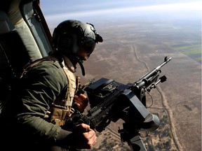 An Iraqi soldier secures an area from a helicopter carrying Iraqi Defense Minister Khalid al-Obeidi who is visiting a military base near Baquba, the capital of Iraq's Diyala province, 35 miles (60 kilometers) northeast of Baghdad, Iraq.