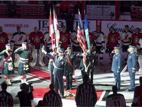 Anthem singer Lyndon Slewidge holds up the microphone as the crowd sings 'O Canada' before the NHL hockey game between the Ottawa Senators and New Jersey Devils Saturday October 25, 2014 in Ottawa.