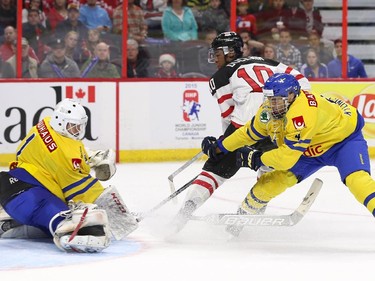 Anthony Duclair #10 of Team Canada watches the puck as Oliver Kylington #4 and Samuel Ward #1 of Team Sweden defend the net in the third period during an World Junior Hockey pre-tournament game at Canadian Tire Centre in Ottawa on December 21, 2014.