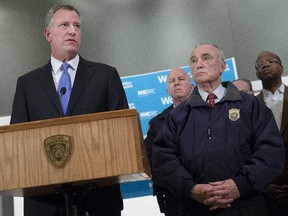 New York City Mayor Bill de Blasio, left, speaks alongside NYPD Commissioner Bill Bratton, right, stands beside during a news conference at Woodhull Medical Center, Saturday, Dec. 20, 2014, in New York.  An armed man walked up to two New York Police Department officers sitting inside a patrol car and opened fire Saturday afternoon, killing both officers before running into a nearby subway station and committing suicide, police said.