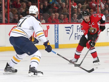 Erik Karlsson #65 of the Ottawa Senators skates with the puck against Nikita Zadorov #51 of the Buffalo Sabres in the first period.