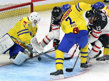 Team Canada's Curtis Lazar (26) battles for the puck with Team Sweden goaltender Samuel Ward (1) and Sebastian Aho (2) during first period exhibition hockey action in preparation for the upcoming IIHF World Junior Championships in Ottawa Sunday, December 21, 2014.