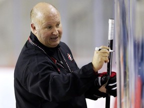 Benoît Groulx draws on a white board during the Canadian junior team's practice in St. Catharines, Ont., on Monday, Dec. 15, 2014. Before leaving Gatineau to coach the national juniors, he lamented the fact his Olympiques have been unable to ice a healthy lineup so far in the 2014-15 QMJHL season.