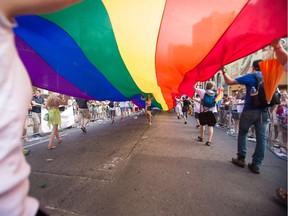 Files: A woman runs under a giant rainbow flag  during the  WorldPride 2014 Parade in Toronto, Canada, June 29, 2014.