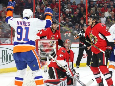 Chris Phillips, Craig Anderson (41) and Cody Ceci (5) of the Ottawa Senators react after the New York Islanders scored during second period action.