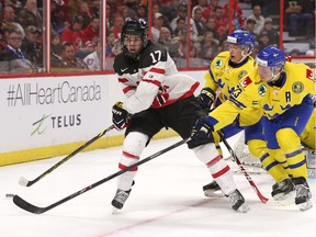Connor McDavid #17 of Team Canada makes a backhand pass against Lucas Wallmark #23 and Gustav Forsling #8 of Team Sweden in the third period during an World Junior Hockey pre-tournament game at Canadian Tire Centre in Ottawa on December 21, 2014. (Jana Chytilova / Ottawa Citizen)  ORG XMIT: 1222 Can v Swe JC24
