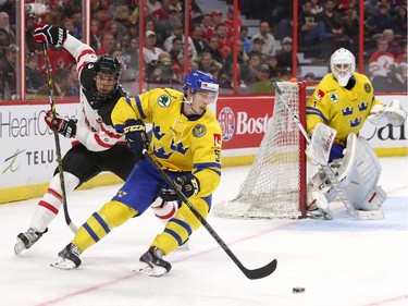 Connor McDavid #17 of Team Canada skates after Robin Norel #5 of Team Sweden as goalie Samuel Ward #1 looks on in the third period during an World Junior Hockey pre-tournament game at Canadian Tire Centre in Ottawa on December 21, 2014.