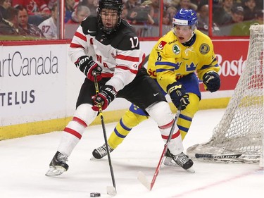 Connor McDavid #17 of Team Canada uses his body to protect the puck against Gustav Forsling #8 of Team Sweden in the third period during an World Junior Hockey pre-tournament game at Canadian Tire Centre in Ottawa on December 21, 2014.