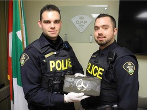 Constables Bradley Giroux, left, and Sebastien Brisson with pouch of hashish discovered in returned rental car.