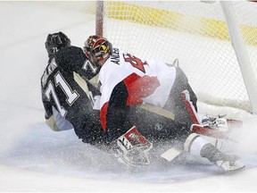 Pittsburgh Penguins' Evgeni Malkin (71) collides with Ottawa Senators goalie Craig Anderson (41) while scoring a goal during the first period of an NHL hockey game in Pittsburgh Saturday, Dec. 6, 2014.(AP Photo/Gene J. Puskar