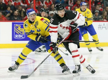 Team Canada's Curtis Lazar, wearing jersey No. 26, battles for the puck against Lucas Wallmark of Team Sweden in the first period at Canadian Tire Centre on Dec. 21, 2014.