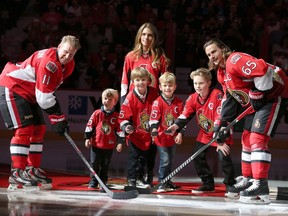 Daniel Alfredsson takes a ceremonial face off with Erik Karlsson (R) his wife Bibi and children William Erik, Loui, Fenix and Hugo after he salutes the crowd before leaving the ice on the day the Ottawa Senators signed him to a one day contract so he could retire as a Senator.