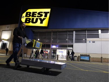 Duke Desabrais carts out his Boxing Day purchase - a new $699 50" large-screen LCD TV - to his car at Best Buy on Merivale Road.