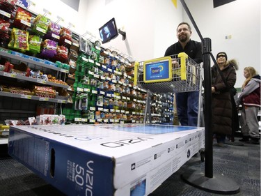 Duke Desabrais waits in line to pay for a 50" large-screen LCD TV at Best Buy on Merivale Road, Dec. 26, 2014.