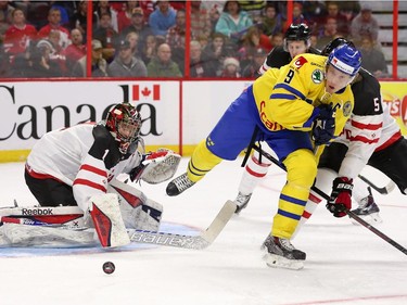 Eric Comrie #1 of Team Canada makes a save against Jacob de la Rose #9 of Team Sweden in the second period during an World Junior Hockey pre-tournament game at Canadian Tire Centre in Ottawa on December 21, 2014.