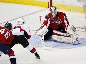 Ottawa Senators right wing Erik Condra (22) has his shot deflected by Washington Capitals goalie Braden Holtby (70) in the third period of an NHL hockey game, Monday, Dec. 22, 2014, in Washington. The Capitals won 2-1.