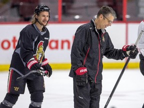 Erik Karlsson has a chuckle with new head coach Dave Cameron as the Ottawa Senators practice.