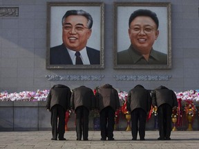 In this Dec. 17, 2013, file photo, North Koreans bow beneath portraits of the late leaders Kim Jong Il and Kim Il Sung in Pyongyang.