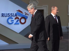 Prime Minister Stephen Harper walks past Russian President Vladimir Putin at the G20 Summit Thursday Sept.5, 2013 in St. Petersburg, Russia.