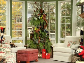 Jaunty bows, greenery, vine wreathes and a couple of pert cardinals help create a handmade Christmas tree in the solarium.