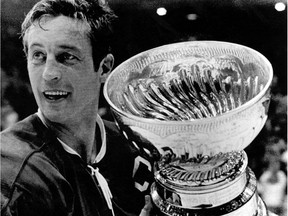 In this May 19, 1971, file photo, Montreal Canadiens team captain Jean Béliveau holds the Stanley Cup in Chicago following the Canadiens 3-2 victory over the Chicago Blackhawks. Béliveau died Tuesday, Dec. 2, 2014. He was 83. The team confirmed the death of the Hall of Fame center and one of the most beloved players in Canadiens history.