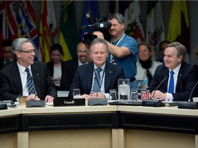 Finance Minister Joe Oliver, left; Parliamentary Secretary to the Finance Minister, Andrew Saxton, right; and Governor of the Bank of Canada Stephen Poloz take part in the finance ministers meeting in Ottawa on Monday.