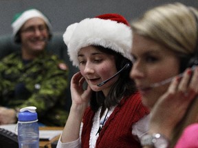 FILE - In this Dec. 24, 2012, file photo, volunteer Katherine Beaupre takes phone calls from children asking where Santa is and when he will deliver presents to their house, during the annual NORAD Tracks Santa Operation, at the North American Aerospace Defense Command, or NORAD, at Peterson Air Force Base, Colo. Santa is poised for another monster year on social media. NORAD Tracks Santa has already attracted a record 1.49 million Facebook "likes" before the journey even begins. And for Christmas Eve 2014, there's a website version for smartphones.