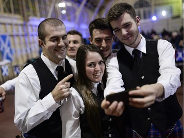 (L-R) Charles-David Mitchell, Jason Baird, Rachel Houlzet, Marshall MacPherson, and Chris Macdonell from Glengarry Pipe Band from Maxville take a selfie during the TD Hogmanay 2014.