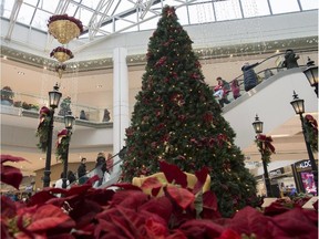 Last minute shoppers pass by a giant Christmas Tree and decorations at Ottawa's Rideau Centre on Christmas Eve on Wednesday, Dec. 24, 2014.