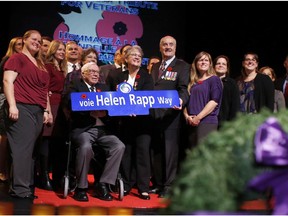 Members of the Rapp family, standing with Veterans Affairs Minister Julian Fantino, receive a commemorative street sign to honour Helen Rapp, a Second World War Veteran, during the 15th annual Candlelight Tribute at the Centrepointe Theatre in Ottawa on Nov. 4, 2014. This is the first year since the founding of the commemorative street naming program in 2005 that a female veteran is honoured. (David Kawai / Ottawa Citizen)