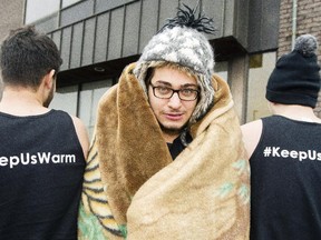 Mohamed El Koussy, centre, freezes outside with a small group of friends as they raise money for Syrian refugees Saturday December 27, 2014. (Darren Brown/Ottawa Citizen)