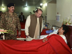 In this picture released by the Inter Services Public Relations, Pakistan's Prime Minister Nawaz Sharif, center, talks to an injured student, a victim of Tuesday's school attack, as Army Chief Gen. Raheel Sharif watches them during their visit to a military hospital in Peshawar, Pakistan, Wednesday, Dec. 17, 2014.