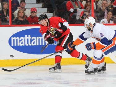 Curtis Lazar #27 of the Ottawa Senators shoots the puck against Nick Leddy #2 of the New York Islanders.