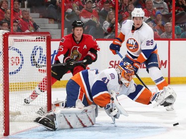 Jaroslav Halak #41 of the New York Islanders covers the puck as team mate Brock Nelson #29 and Chris Neil #25 of the Ottawa Senators look on in the second period.