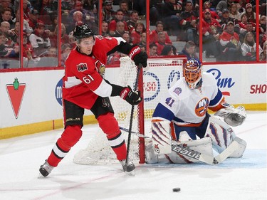 Mark Stone #61 of the Ottawa Senators makes a pass as Jaroslav Halak #41 of the New York Islanders guards his net.