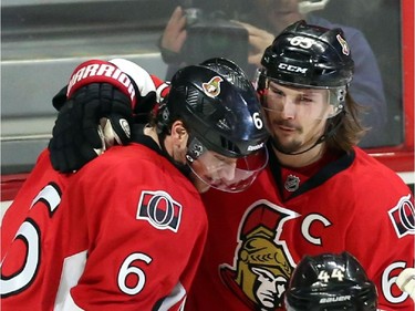 Ottawa Senators' Bobby Ryan (6) celebrates his third goal against the Buffalo Sabres with teammates Erik Karlsson (65) as fans throw hats on the ice during third period NHL hockey action.