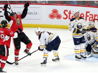Buffalo Sabres' Josh Gorges (4), Andre Benoit (61) and goaltender Jhonas Enroth (1) react as Ottawa Senators' Bobby Ryan (6) celebrates his second goal of the game with teammate Mike Hoffman (68) during second period NHL hockey action.