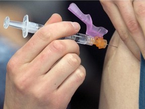 A man receives the flu shot at a City of Ottawa pop up clinic in the west end, January 11, 2014.