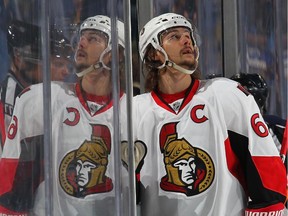 Erik Karlsson #65 of the Ottawa Senators delivers equipment to a teammate in the penalty box in their game against the Buffalo Sabres on December 15, 2014 at the First Niagara Center in Buffalo, New York.