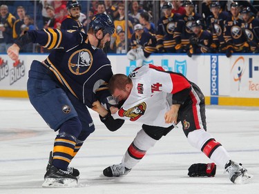 Tyson Strachan #24 of the Buffalo Sabres fights with Mark Borowiecki #74 of the Ottawa Senators.