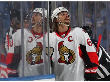 Erik Karlsson #65 of the Ottawa Senators delivers equipment to a teammate in the penalty box.