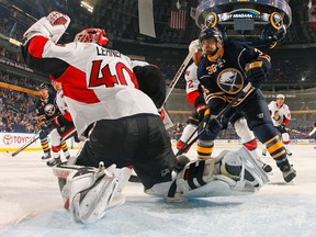 Robin Lehner #40 of the Ottawa Senators makes a glove save in front of Patrick Kaleta #36 of the Buffalo Sabres and Eric Gryba #62 of the Senators.