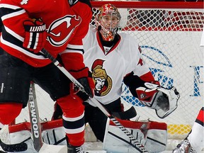 Craig Anderson #41 of the Ottawa Senators keeps his eyes on the action while being screened during the game against the New Jersey Devils at the Prudential Center on December 17, 2014 in Newark, New Jersey.