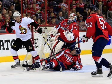 Erik Condra #22 of the Ottawa Senators collides with goalie Braden Holtby #70 and Jack Hillen #38 of the Washington Capitals as Mike Green #52 looks on after Condra scored a second period goal.