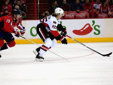 Erik Karlsson #65 of the Ottawa Senators moves the puck in front of Nicklas Backstrom #19 of the Washington Capitals during the first period.