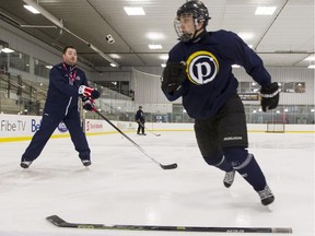 Pat Malloy, the new Buffalo Sabres skating coach and GM of the Pembroke Lumber Kings,  left, takes at look at the skating technique of Ty Brunet from the Gloucester Rangers AA hockey team at the Bell Sensplex in Kanata Tuesday, December 16, 2014.