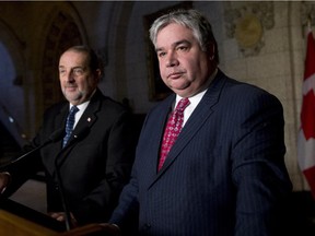 Government House Leader Peter Van Loan (r) takes questions during an end-of-session news conference in the Foyer of the House of Commons Wednesday.