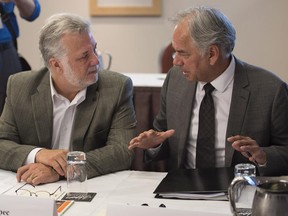 Quebec Premier Philippe Couillard, left, chats with Ghislain Picard of the Assembly of First Nations at a meeting of premiers and aboriginal leaders in Charlottetown on Wednesday, August 27, 2014.