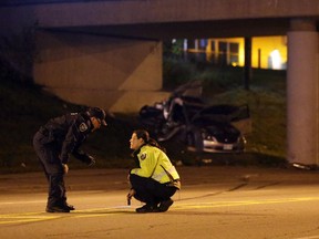 Police investigate what was originally thought to be a single-vehicle collision where two males were injured, one seriously, on Merivale Rd. south of Colonnade on Friday, October 24, 2014.