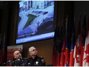 RCMP Commissioner Bob Paulson, left, and Ottawa Police Chief Charles Bordeleau watch surveillance video from the Oct. 22 shooting on Parliament Hill at a press conference the day after.